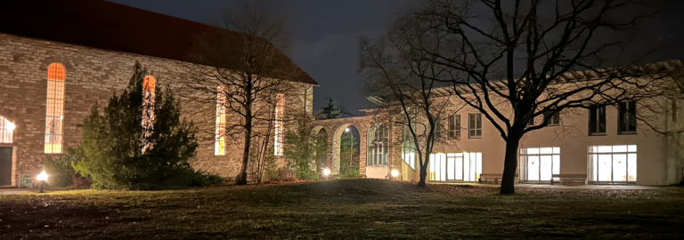 Blick auf Kirche und Gemeindehaus am Abend beleuchtet