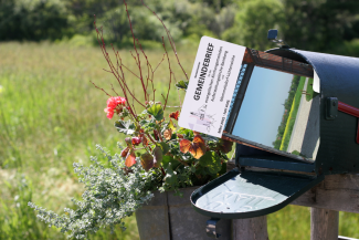 Gemeindebrief steckt in schwarzem Briefkasten